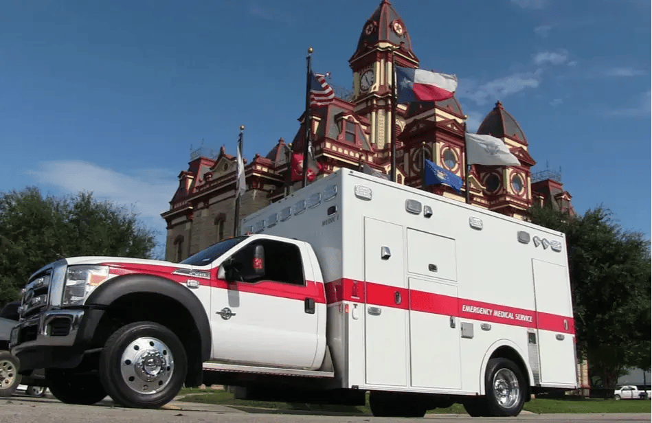 Demers Type I ambulance with a modular patient compartment, exterior storage compartments, and emergency lighting.