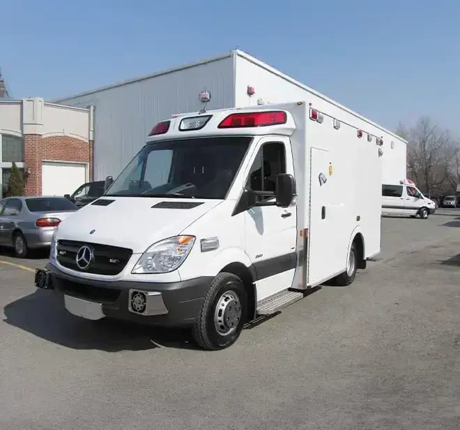 Demers Type III ambulance with a van chassis, modular patient compartment, emergency lighting, and exterior storage compartments.