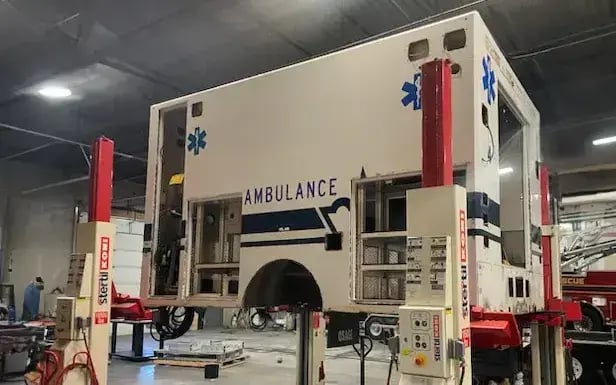 Image of an ambulance module on the lift to be replaced with a new chassis