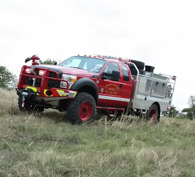 Skeeter brush truck with a flatbed body, wildland firefighting equipment, and storage for off-road fire response operations.