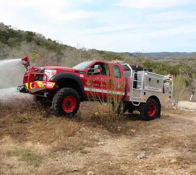 Skeeter step-side brush truck equipped for wildland firefighting with off-road capability and exterior equipment storage.
