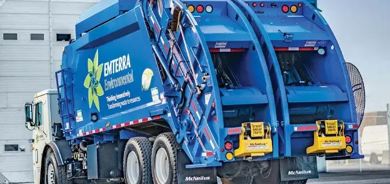 Emterra Environmental split-body rear loader truck featuring dual compartments for simultaneous recycling and waste collection, designed to improve municipal collection efficiency and reduce fleet operations.