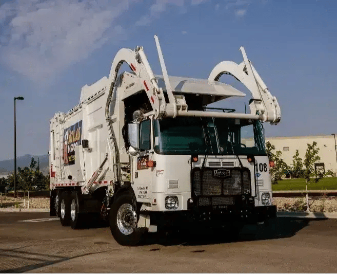 McNeilus front-loader refuse truck designed for commercial waste collection, featuring automated lifting arms and high-capacity sanitation operations.