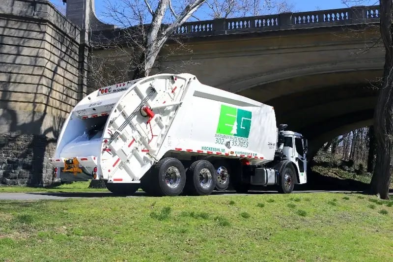 McNeilus rear-loader refuse truck operating in an urban environment, providing efficient municipal waste collection and sanitation services.