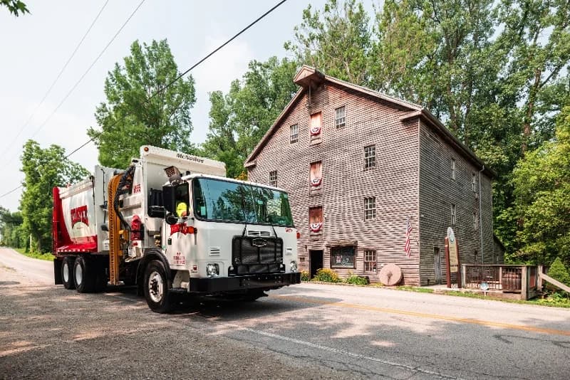 McNeilus ZR automated side loader installed on an Autocar chassis for residential waste collection.