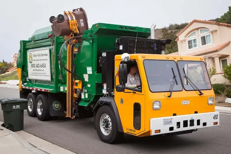 McNeilus ZR automated side loader mounted on a Crane Carrier chassis for high-efficiency waste collection operations.