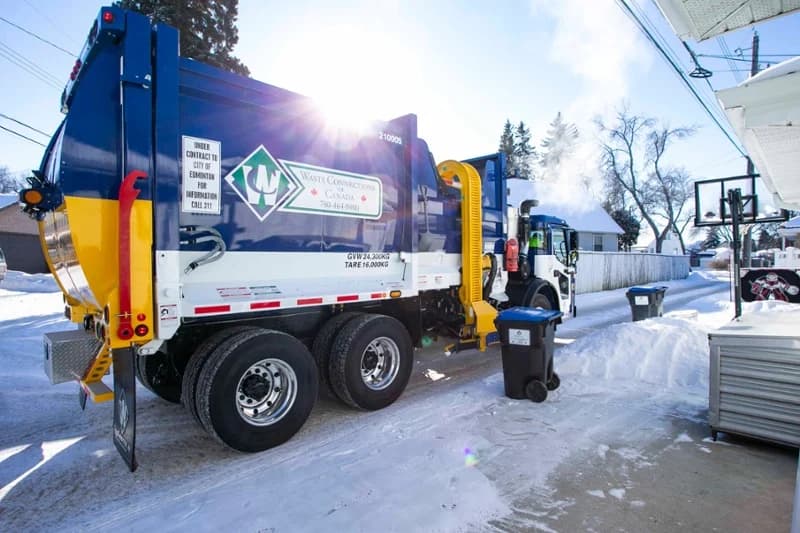 Rear side view of a McNeilus ZR automated side loader mounted on a Mack refuse truck chassis.