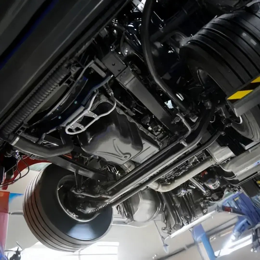 Underside view of heavy equipment highlighting structural components, mechanical systems, and service-access areas used for inspection and maintenance.