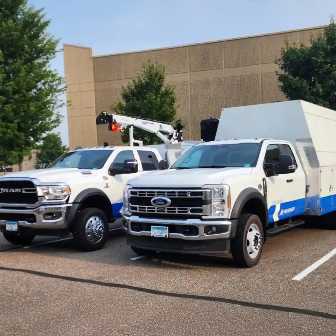 Road service support trucks parked outside a commercial facility, showcasing mobile maintenance vehicles equipped for on-site equipment repair, diagnostics, and field service.