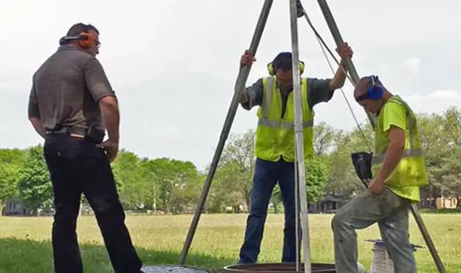 Workers using Sonetics wireless headsets outdoors, maintaining clear team communication and coordination during field operations and equipment-related tasks.
