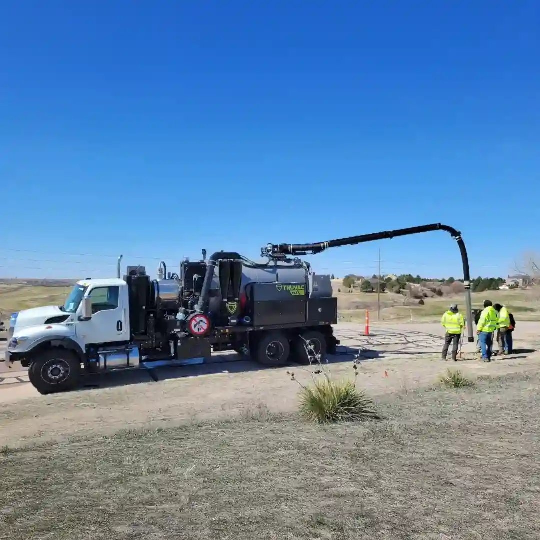 TRUVAC hydro excavation truck performing utility excavation outdoors, with crew members operating the vacuum boom for safe, precise underground utility exposure.