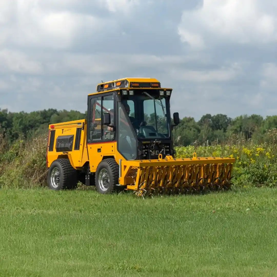 Trackless MT7 municipal tractor equipped with a front-mounted aerator for improving soil health and maintaining parks, sports fields, and large turf areas.