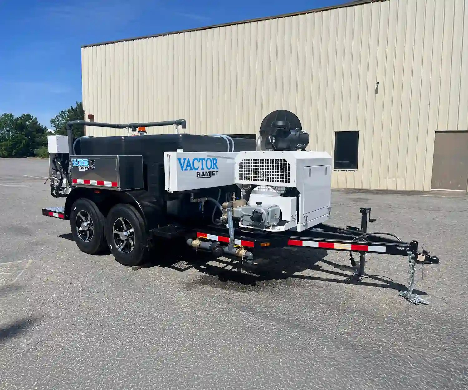 Vactor Ramjet trailer jetter shown outdoors, featuring a water tank, hose reel system, and high-pressure cleaning equipment for sewer maintenance applications.