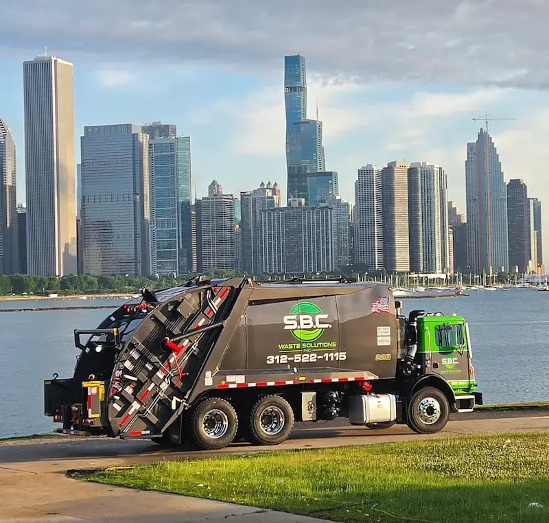 McNeilus refuse and recycling truck operating in an urban environment, supporting residential and commercial waste collection services.