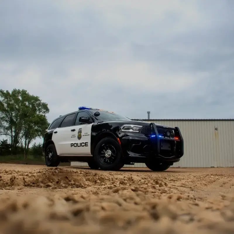 Marked police SUV with emergency lights activated, representing law enforcement vehicles and public safety response solutions.