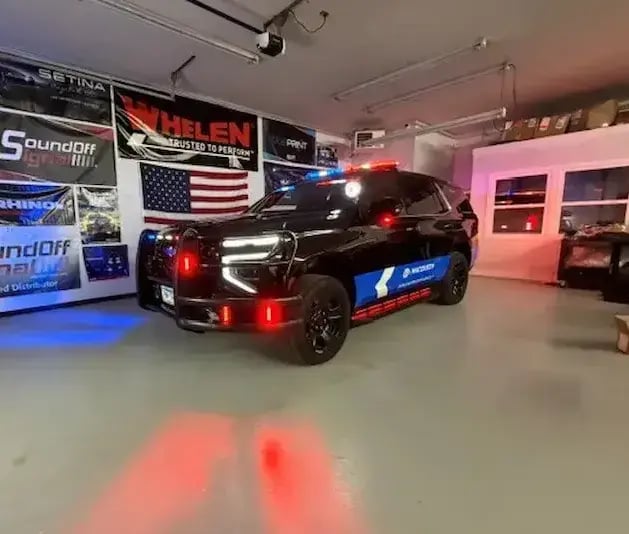 Upfitted Chevrolet Tahoe police vehicle with emergency lighting activated, showcasing law enforcement equipment integration and vehicle customization services.