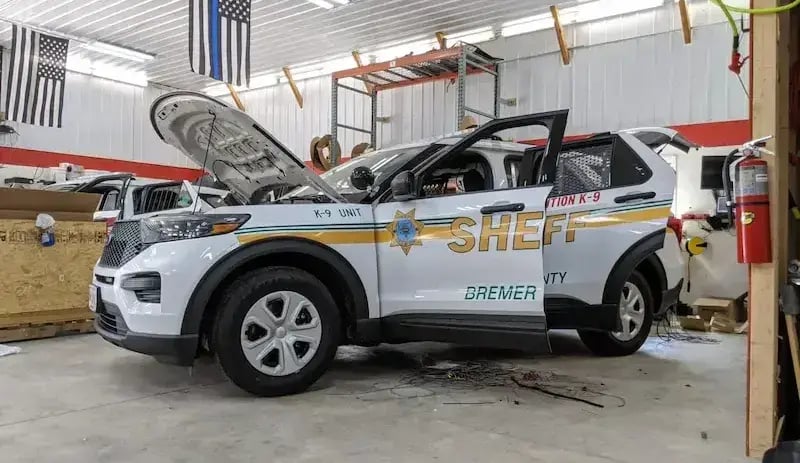 Bremer County Sheriff's K-9 patrol SUV undergoing emergency vehicle upfitting with integrated public safety equipment, electronics, and custom law enforcement installation.