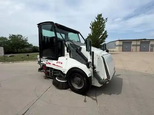 Front passenger-side view of a 2018 Elgin Pelican NP street sweeper.
