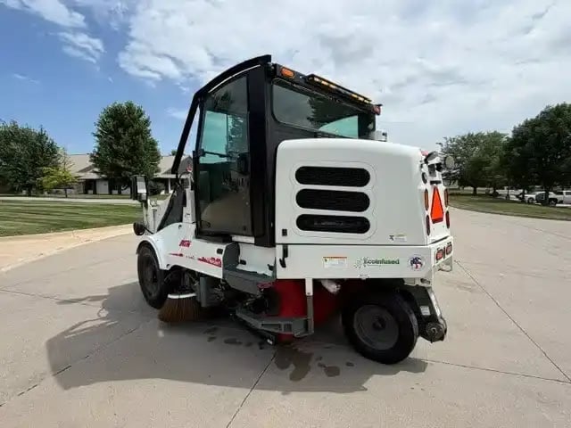 Rear driver-side view of a 2018 Elgin Pelican NP street sweeper.