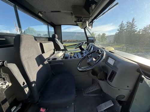 Driver seating and cab interior of a 2016 Elgin Pelican NP street sweeper.