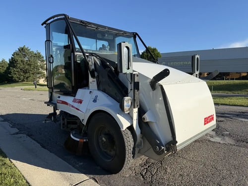 Front driver-side angle of a 2016 Elgin Pelican NP street sweeper.