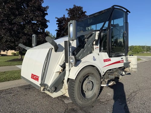 Front driver-side view of a 2016 Elgin Pelican NP street sweeper.