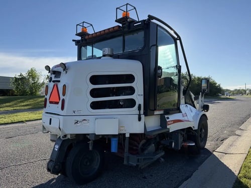 Rear passenger-side angle of a 2016 Elgin Pelican NP street sweeper.