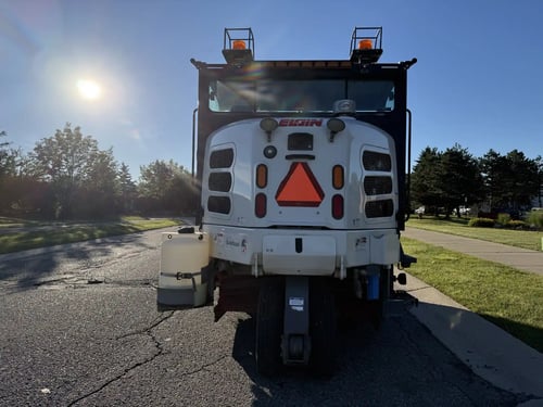 Rear view of a 2016 Elgin Pelican NP street sweeper.
