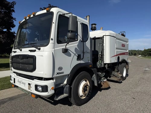 Front right angle of a used 2013 Elgin Whirlwind street sweeper.