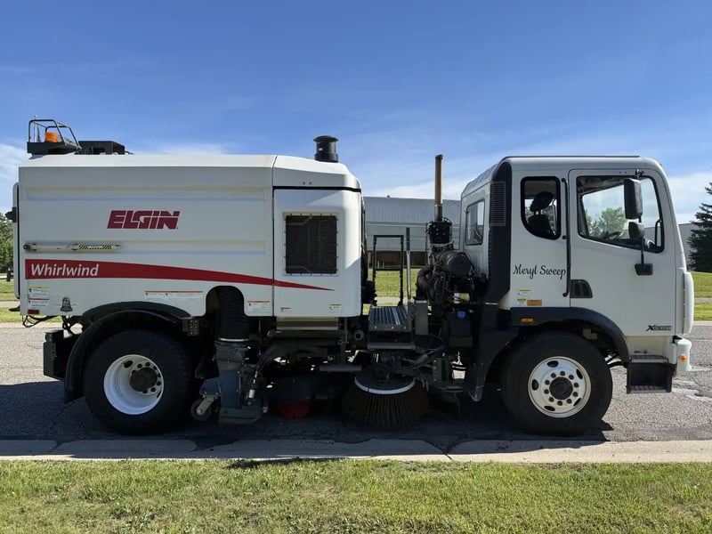 Passenger-side profile of a used 2013 Elgin Whirlwind regenerative air street sweeper on an Autocar Xpeditor chassis.