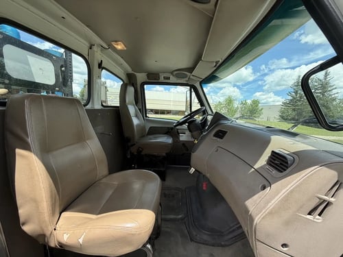 Passenger-side interior of the 2006 Vactor 2100 with vinyl seating and clean commercial cab.