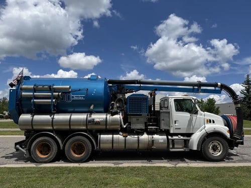 Full passenger-side profile of a 2006 Vactor 2100 combination sewer cleaner with hydraulic boom and debris tank.