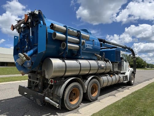 Rear driver-side view of the 2006 Vactor 2100 showing the debris tank vacuum system and rear discharge.