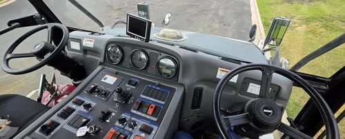 Dashboard and dual steering controls inside a 2015 Elgin Pelican NP Dual street sweeper.