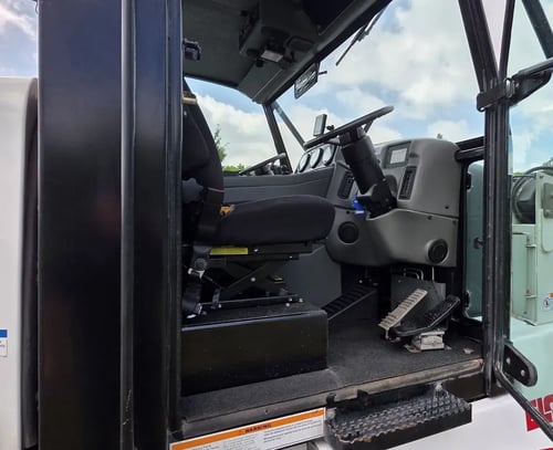 Driver entry area of a 2015 Elgin Pelican NP Dual street sweeper.