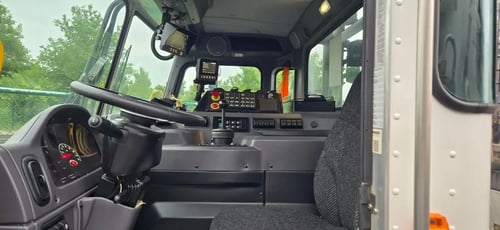 Driver compartment and controls inside 2026 McNeilus Atlantic Commercial front loader refuse truck