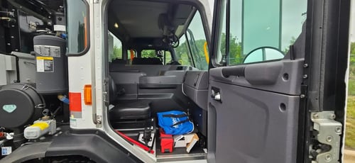 Passenger side cab interior of 2026 McNeilus Atlantic Commercial front loader garbage truck