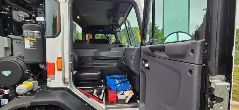 Passenger side cab interior of 2026 McNeilus Atlantic Commercial front loader garbage truck
