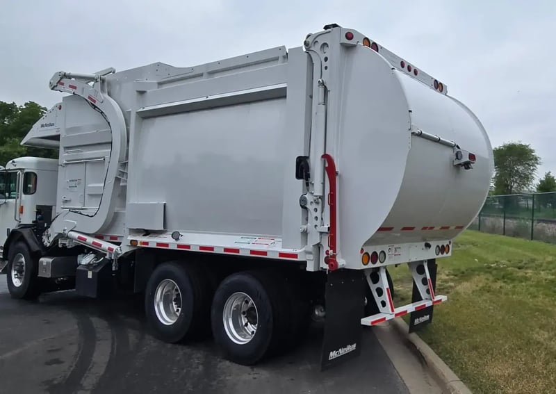 Rear driver side angle of 2026 McNeilus Atlantic Commercial 40 yard front loader refuse truck