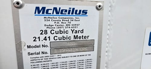 Manufacturer data plate showing specifications for a McNeilus Atlantic 40-yard front loader.