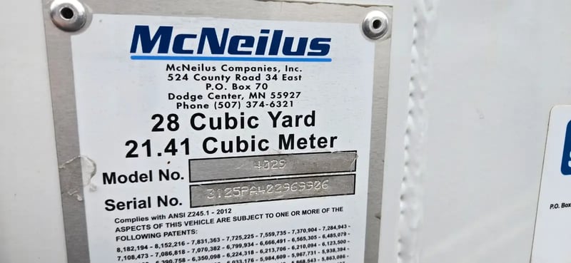 Manufacturer data plate showing specifications for a McNeilus Atlantic 40-yard front loader.
