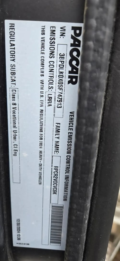 PACCAR VIN and emissions information label on a McNeilus Atlantic front loader refuse truck.