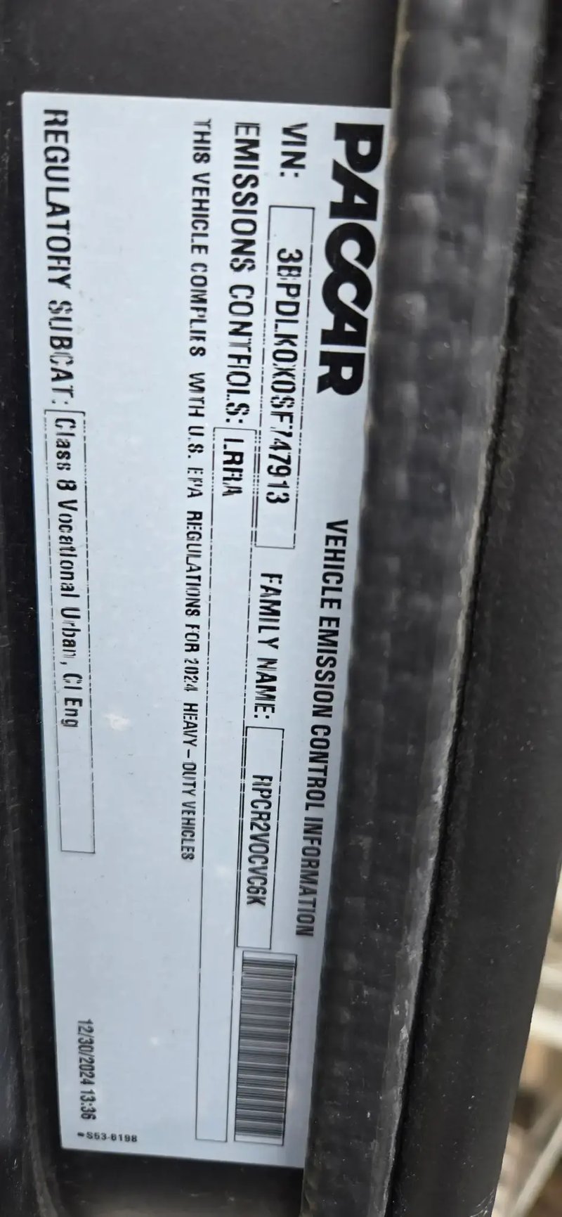 PACCAR VIN and emissions information label on a McNeilus Atlantic front loader refuse truck.