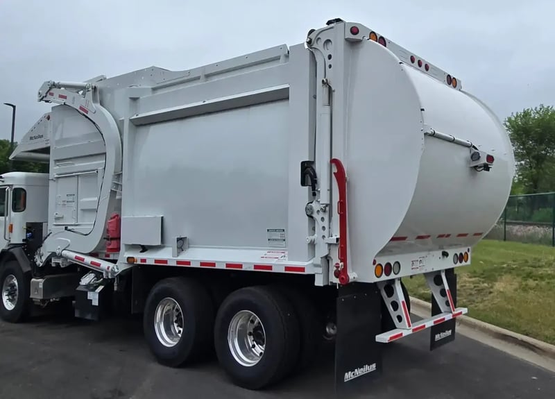 Rear driver-side angle of a McNeilus Atlantic 40-yard front loader refuse vehicle.