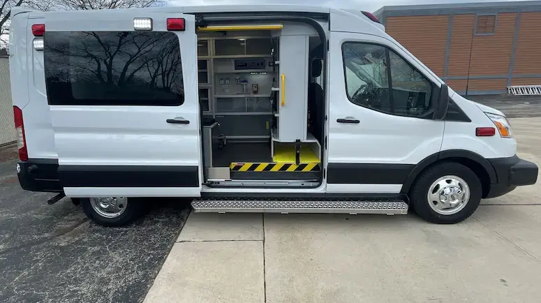 Demers Type II Transit TSE ambulance with a van-based body, emergency lighting, side access doors, and exterior equipment compartments.