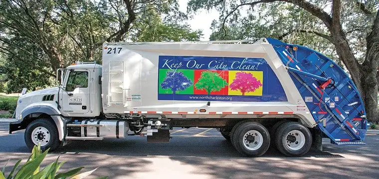 McNeilus rear-loader refuse truck providing municipal waste collection services, supporting clean and sustainable community sanitation operations