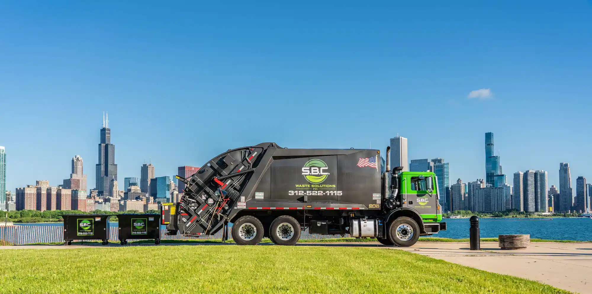 SBC Waste Solutions rear loader garbage truck parked along Chicago’s lakefront with the city skyline in the background, showcasing commercial and municipal waste collection services.