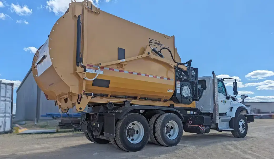 Titan Olympian Hooklift unit displayed outdoors, featuring a high-capacity debris collection body and hooklift-compatible design for efficient seasonal cleanup operations.
