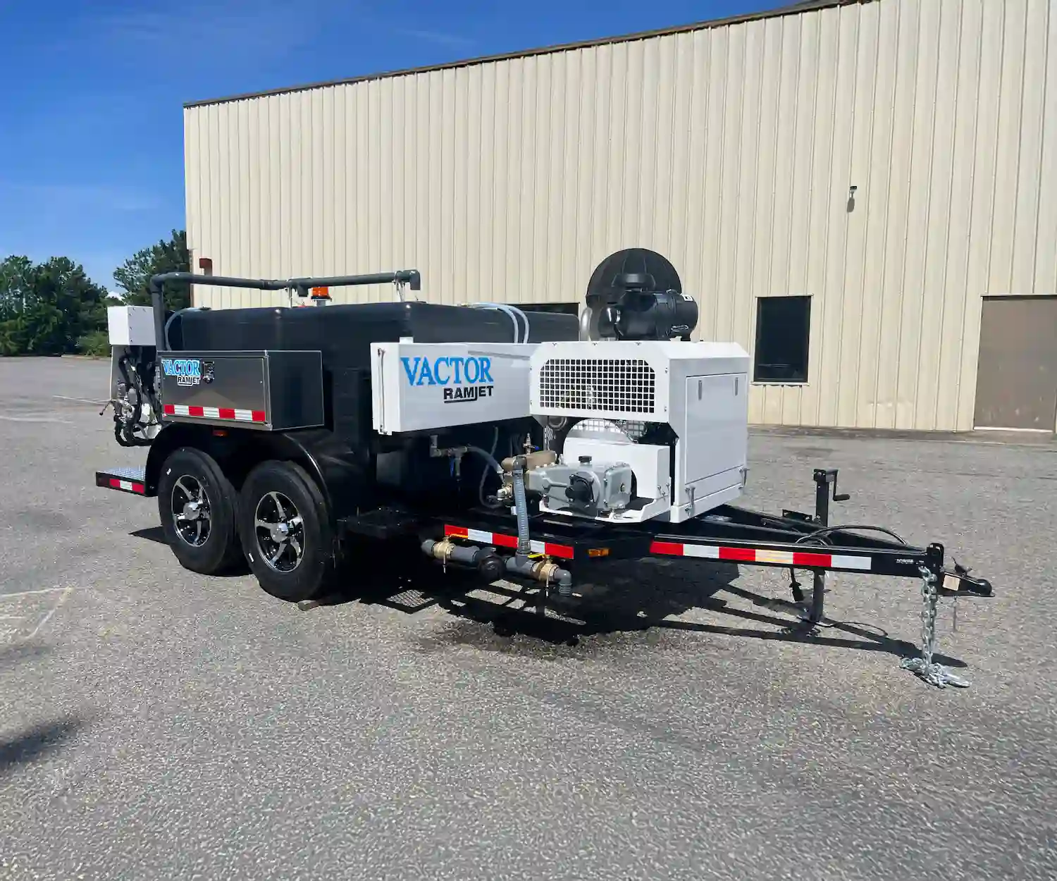 Vactor Ramjet trailer jetter shown outdoors, featuring a water tank, hose reel system, and high-pressure cleaning equipment for sewer maintenance applications.