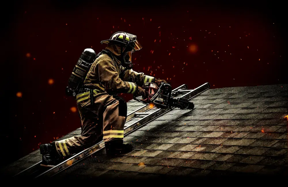 Firefighter equipped with MSA SCBA gear and respiratory protection while working from a roof ladder.